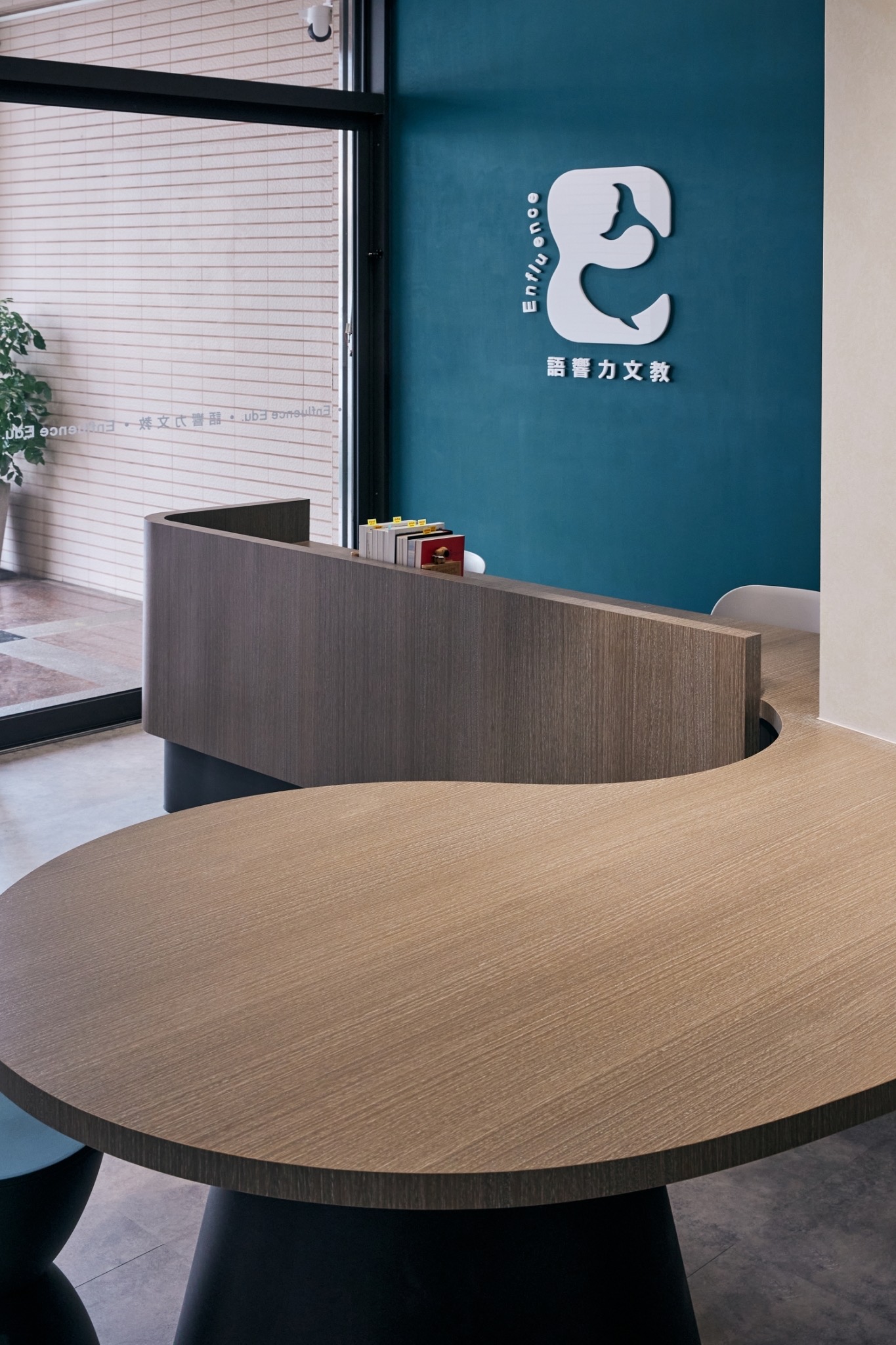 Curved wooden tables and the Enfluence brand wall