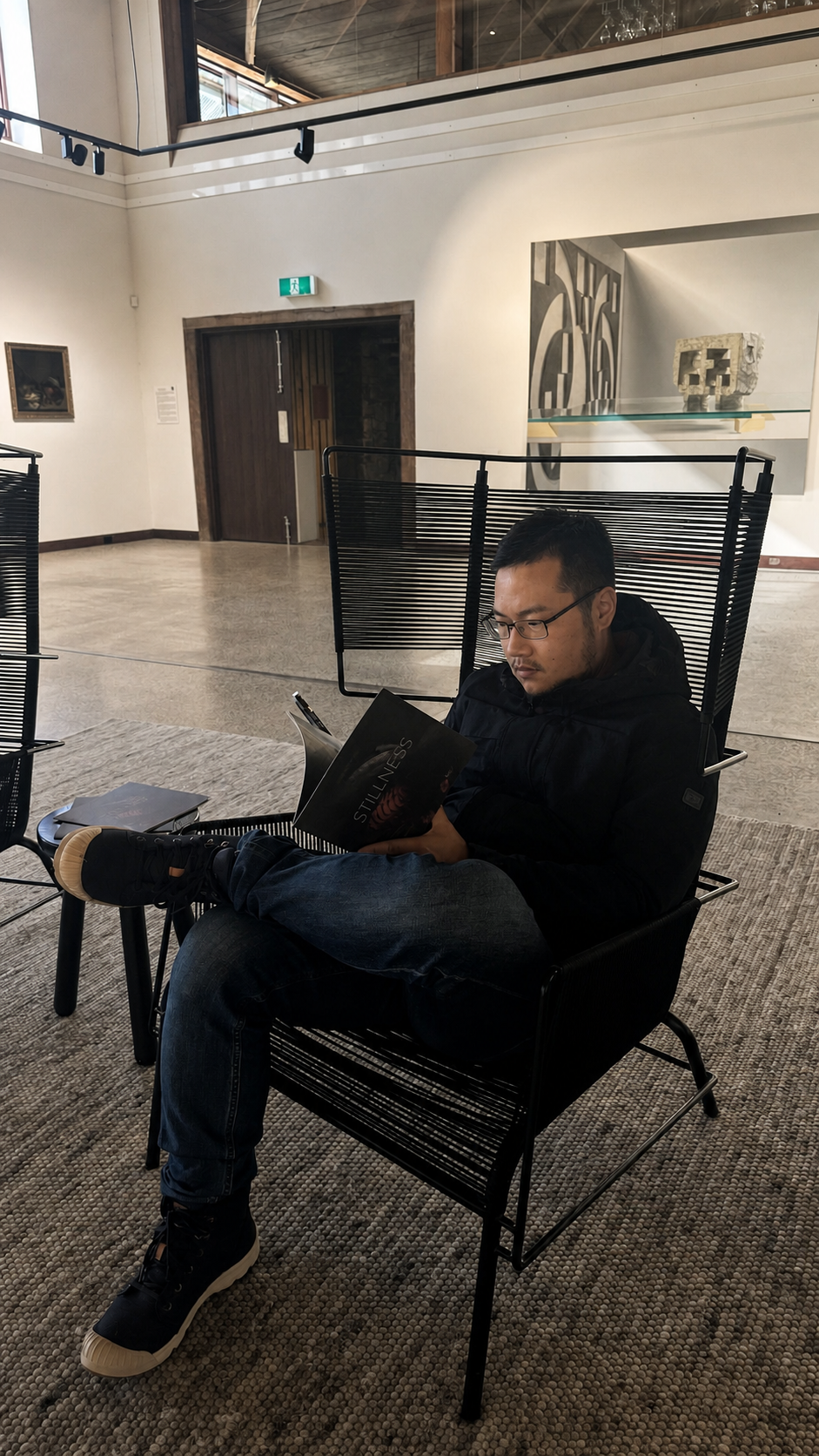 Alejandro reading in a quiet gallery space